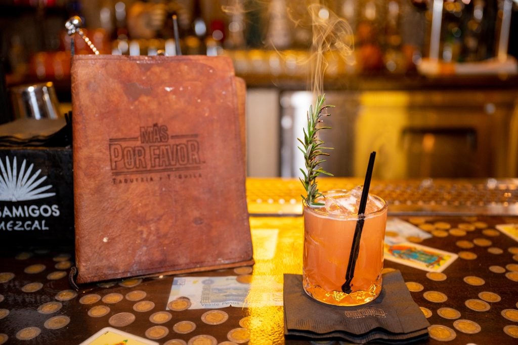 a drink with a sprig of rosemary on top of it