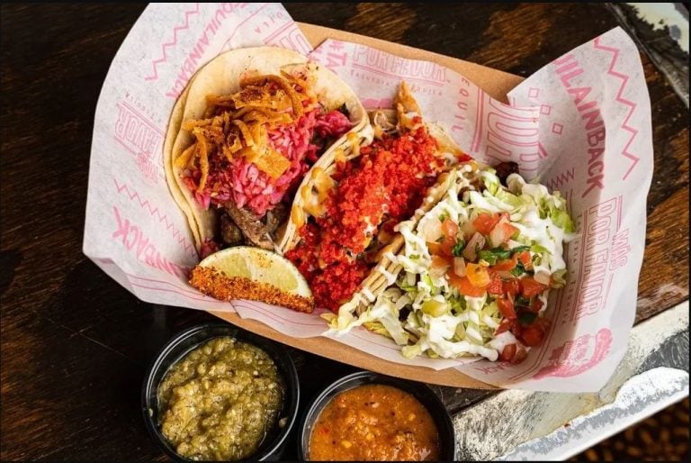 Three carne asada street tacos served at Mas Por Favor in Las Vegas on branded paper in a metal tray