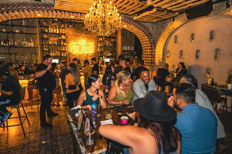 Guests enjoying food and cocktails inside Mas Por Favor’s lively Las Vegas speakeasy — the kind of hidden hangout people discover while searching for bold taco salad dining spots around the city.